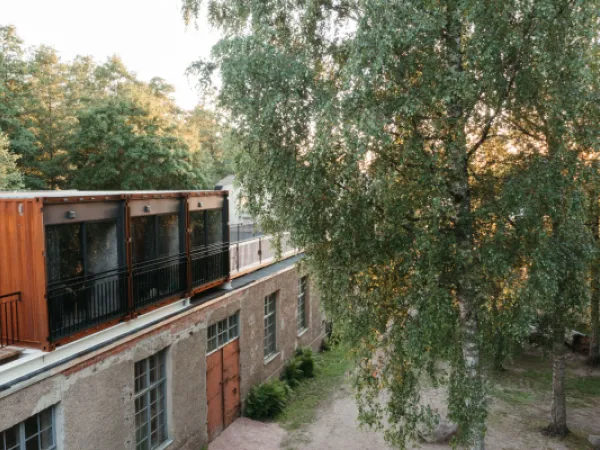 Nainen katselee kattohuoneiston ikkunasta avautuvaa maisemaa.